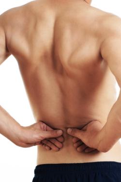 Man feels his lumbar back pain with his hands