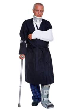 Photo of a mature male with various injuries on a crutch, he's wearing a neck brace, arm sling and leg cast and has a black eye, isolated on a white background.
