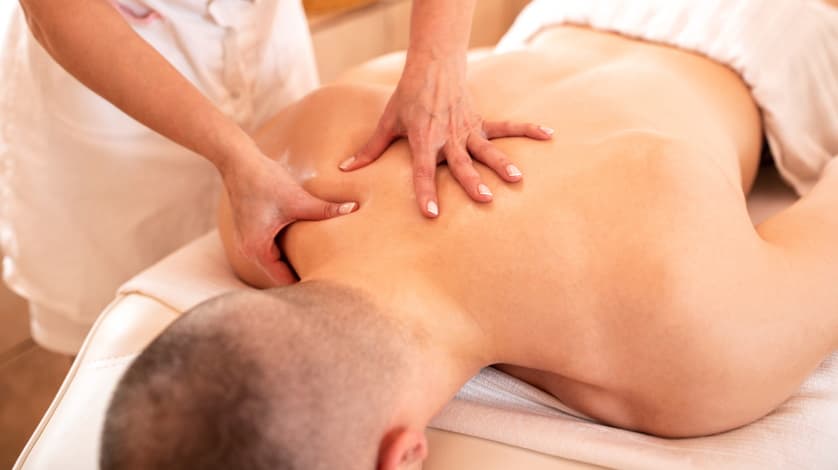 Man lying on stomach and getting a remedial trigger point massage