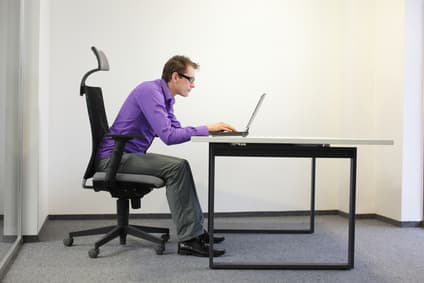 Man sitting in front of the computer in a bad posture
